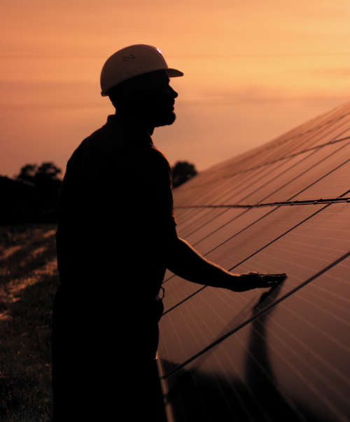Image of an assistance technical worker in uniform checking the operation and efficiency performance of photovoltaic solar panels.