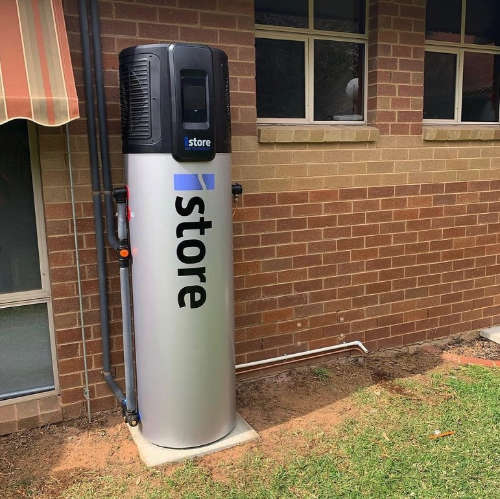 Image of an iStore 180L Solar Hot Water heater installed against a red brick exterior wall